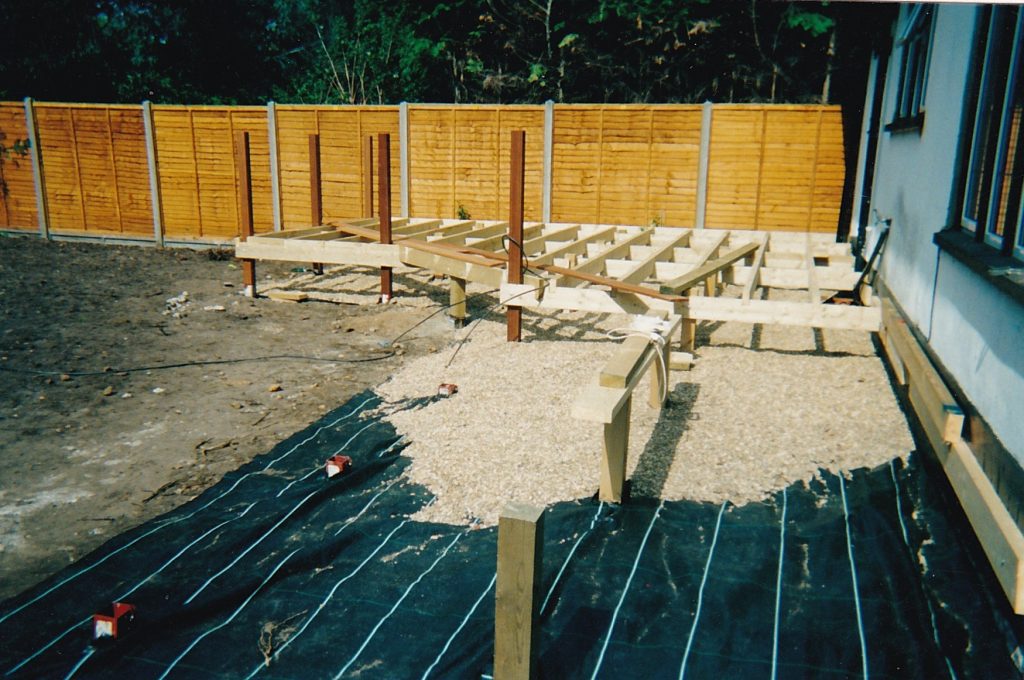 installation of timber frame with 4" x4" posts inserted into metal stirrups and 6" x 2" joists