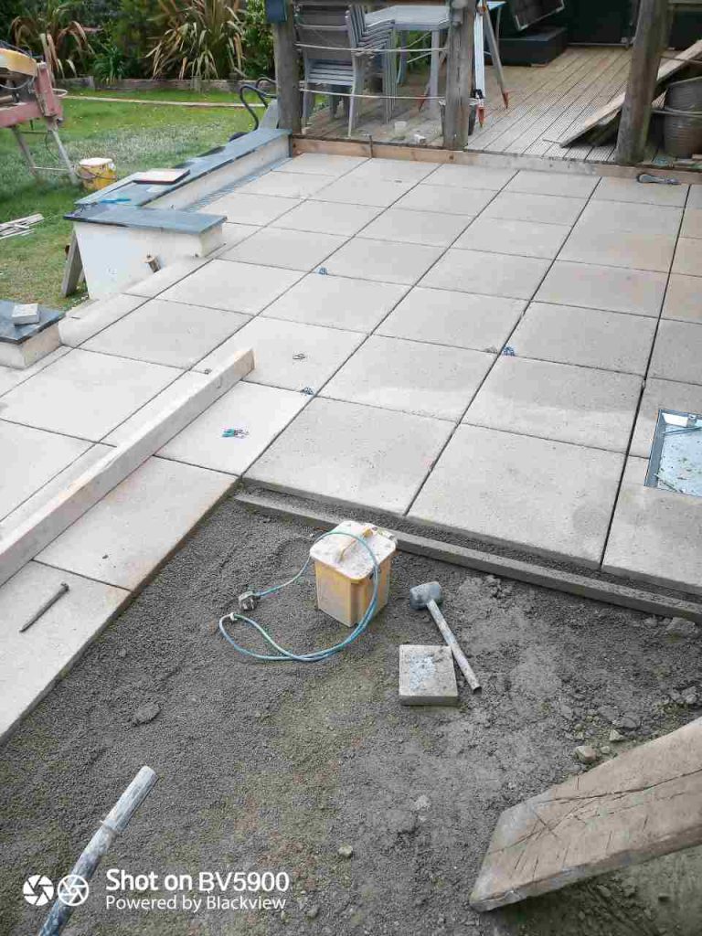 Dry laying Saxon paving on screeded bed of coarse sand and cement