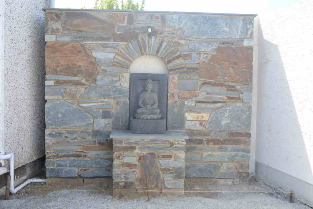 Cornish stone wall and plinth with arch and Buddha water feature