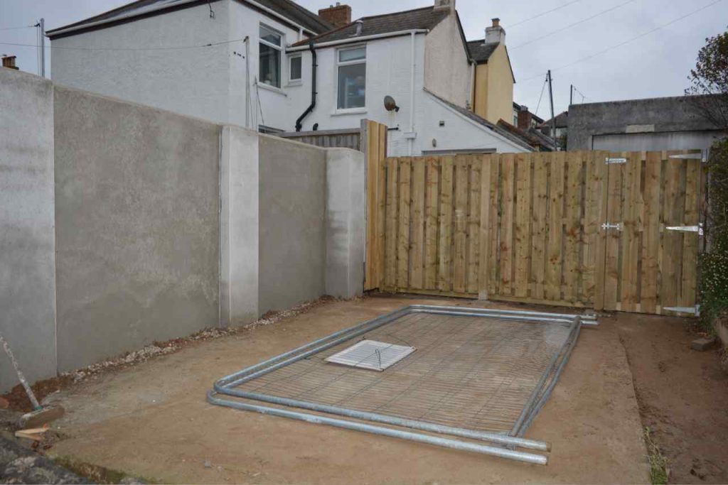 Rendered garden boundary wall with hit and miss timber fence and gate