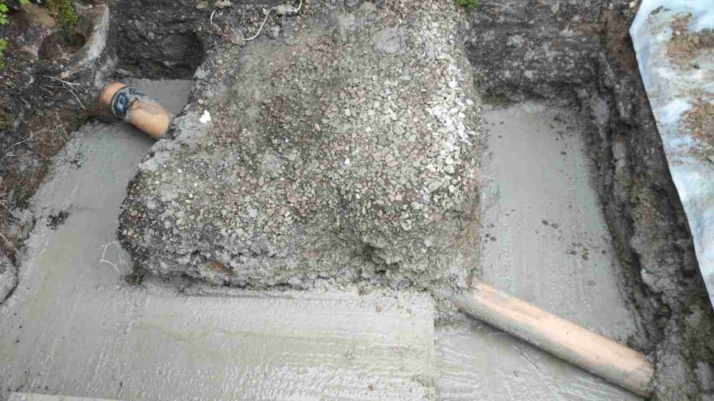 Footings for porch stepped under soak-a-way pipe